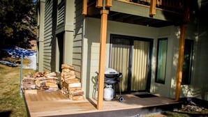 A covered porch with a grill and firewood. - Pet-Friendly Quiet Corner Cabin, Relaxing Location. Near Beautiful Trails (Mammoth Lakes)