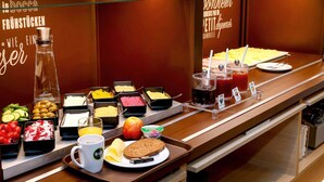 Un bufé con diversas opciones de comida, incluyendo frutas, quesos y jugos.