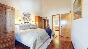 Un dormitorio con cama, armario de madera y espejo.