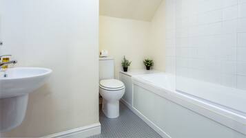 A bathroom with a white sink, toilet, and bathtub.