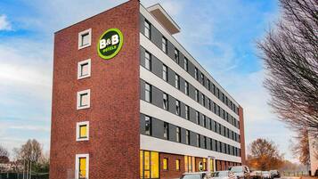 Ein Bed and Breakfast Hotel mit moderner Ziegel-Fassade, mehreren Etagen und einer Reihe geparkter Autos davor.