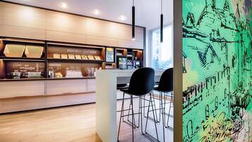 A modern kitchen with wooden cabinets, a breakfast bar, and a large window.