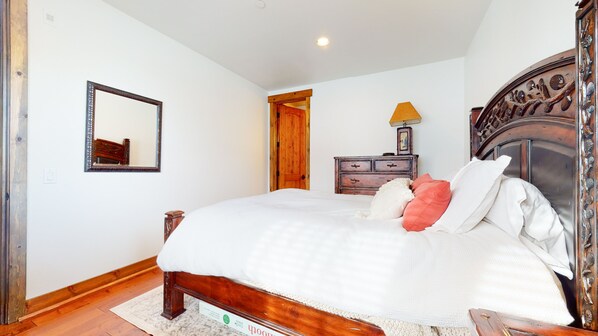 A bedroom with a wooden bed, a dresser, a mirror, and a door. - One of a Kind, Pet-Friendly, Beautiful & Spacious, Washer/Dryer, 1-Car Garage (Mammoth Lakes)