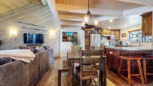 Una cucina moderna con mobili in legno, un'isola centrale e un'area pranzo con tavolo e sedie in legno.