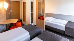 A modern hotel room with a bed, a desk, a chair, and a TV. - B&B Hotel Magdeburg-City (Magdeburg)