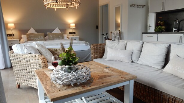 Un dormitorio moderno con una cama grande, un sofá y una mesa de comedor.
