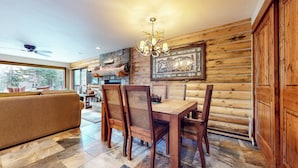 A cozy log cabin interior with a dining table, chairs, and a fireplace. - Remodeled Cabin, Balcony. Near Walking Trails. Pool & Tennis Courts On-site (Mammoth Lakes)