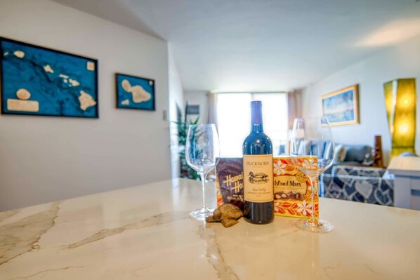 Une table en marbre avec une bouteille de vin Duckhorn, un verre et une boîte de chocolats Hawaiian Ho.