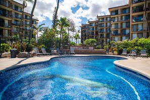 Relax by the resort pool surrounded by lounge chairs and umbrellas.