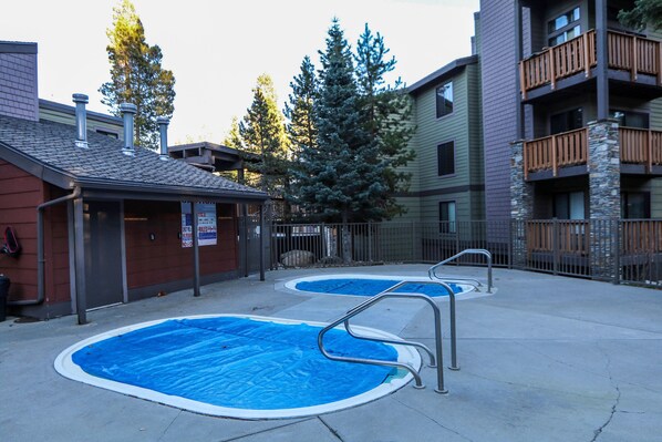 A residential area with two swimming pools, a covered patio, and a building with balconies. - Remodeled, Spacious Corner Unit, Walk to Eagle Lodge, Slopes & Shuttle (Mammoth Lakes)