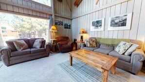 A cozy living room with two sofas, a wooden coffee table, and a lamp.