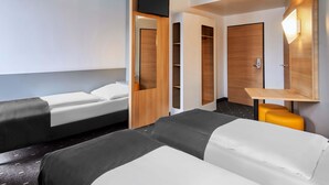 A hotel room with two beds, a desk, a wardrobe, and a TV. - B&B Hotel Mainz-Hbf (Mainz)
