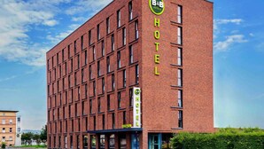 A modern brick building with a sign reading "B&B HOTELS" and a reception area visible at the ground level. - B&B Hotel Mainz-Hbf (Mainz)