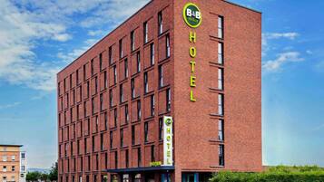 A modern brick building with a sign reading "B&B HOTELS" and a reception area visible at the ground level.