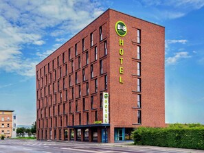 Un bâtiment moderne en briques, sur lequel on peut lire l’inscription « B&B HOTELS », et dont la réception est visible au niveau du rez-de-chaussée.