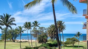 A view of a beach with palm trees and a clear sky. - Refined Oceanfront Vistas (Kihei)