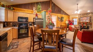 A kitchen with wooden cabinets, a refrigerator, a microwave, and a dining table with chairs.