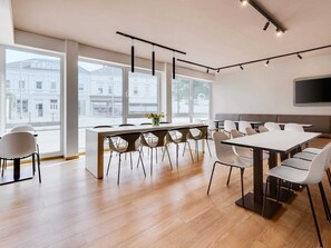 A modern conference room with a long table, multiple chairs, and a central island. - B&B Hotel Oldenburg (Oldenburg)
