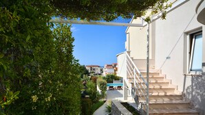 A pathway leading to a building with a pool, surrounded by greenery. - "Villa Karmen Split, Private Garden & Heated Pool (Podstrana)