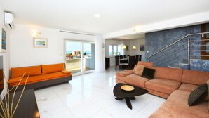 A modern living room with a sofa, a coffee table, and a staircase. - "Villa Karmen Split, Private Garden & Heated Pool (Podstrana)
