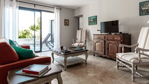A living room with a sofa, armchair, and a television on a wooden cabinet.