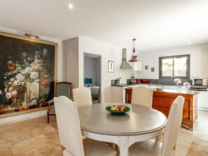 A dining area with a round table, chairs, and a painting on the wall. - La Verdière -  Contemporary house with garden and private pool (L'Isle-sur-la-Sorgue)