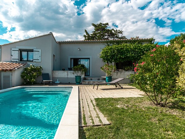 A residential property with a swimming pool, a patio with a chair and a table, and a garden with various plants and flowers. - La Verdière -  Contemporary house with garden and private pool (L'Isle-sur-la-Sorgue)