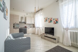 A modern living room with a TV, sofa, and artwork on the wall.
