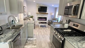 A modern kitchen with granite countertops, stainless steel appliances, and a built-in fireplace.