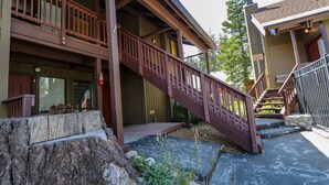 A wooden building with a balcony, a staircase, and a stone wall. - Spacious & Updated. Across from The Village, Private Balcony & Gas Grill (Mammoth Lakes)
