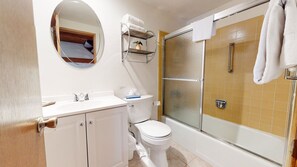 Une salle de bain équipée de toilettes, d’un lavabo et d’une douche.