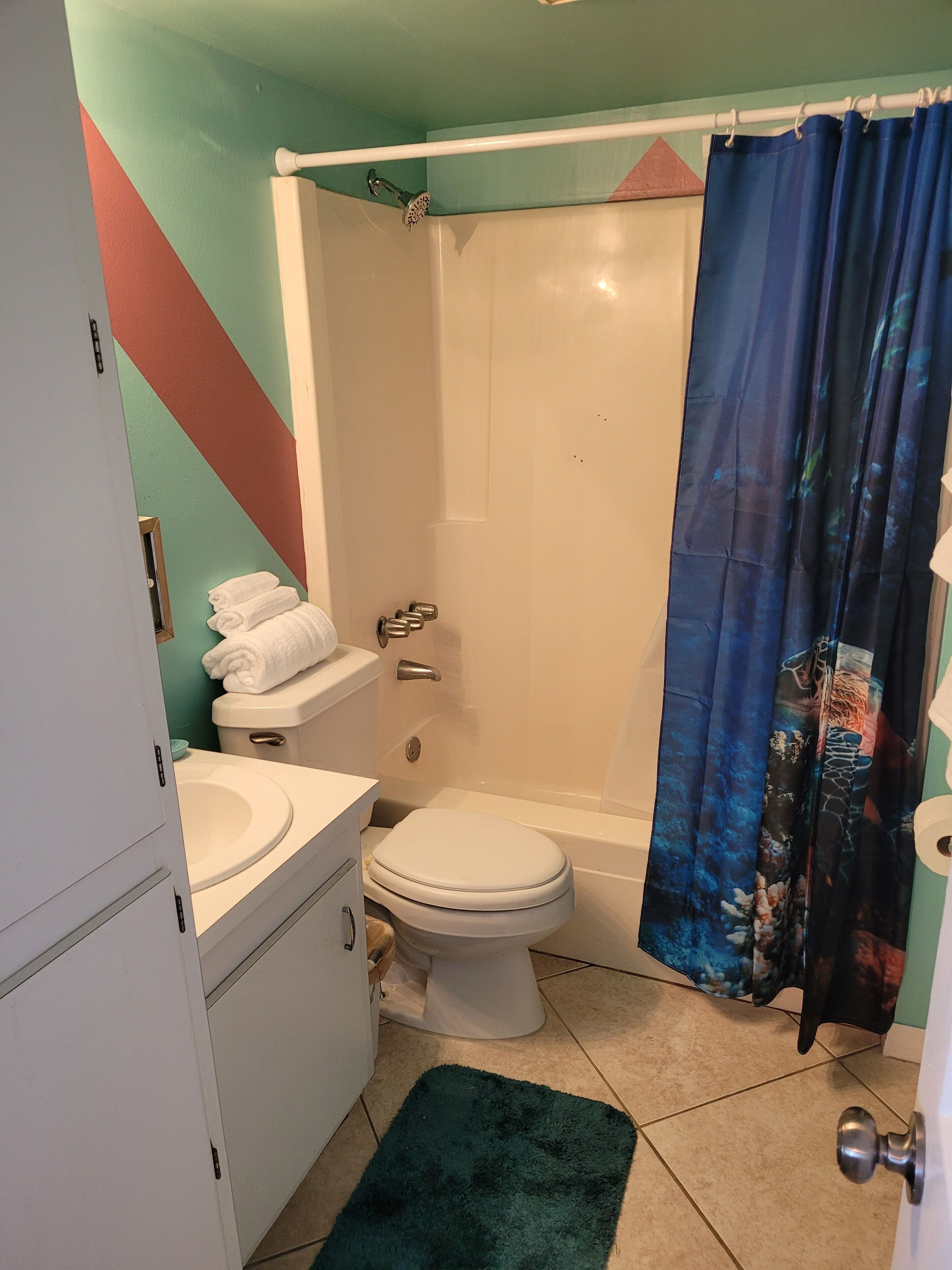 A bathroom with a toilet, sink, and shower.