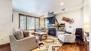 A spacious living room with a fireplace, a television, and comfortable seating.