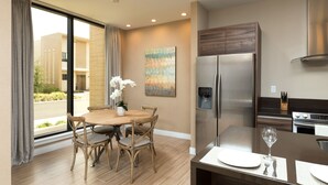 A modern kitchen with a stainless steel refrigerator, a dining table with chairs, and a large window with curtains. - Gorgeous Home! New, Near Disney, Free Parking, Free Wi-Fi Family Friendly Pool (Kissimmee)