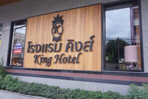 En hotellskylt med namnet ”Isdisu Awa King Hotel” och ett vapensköldliknande emblem ovanför.