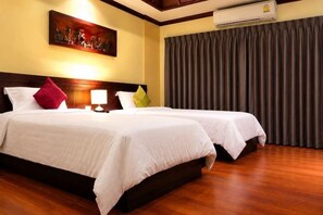 A hotel room with two beds, a painting on the wall, and a large window with curtains. - King Hotel (Loei)