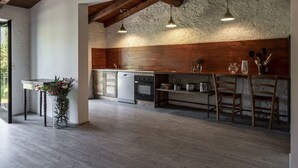 A spacious kitchen with wooden beams, a stone wall, and pendant lighting. - Le Chiusure - home 'Castello' (Lake Garda, Lombardy)