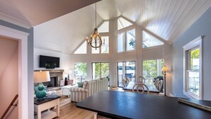 A spacious kitchen with a large island, a dining area with a table and chairs, and a cozy seating area with a sofa and a lamp. - Cozy Cottage at Lake Oconee • Walk-Out Patio • Scenic Porch • Sleeps 8 (Eatonton)