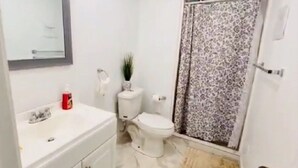 Un baño con inodoro, lavabo y zona de ducha.