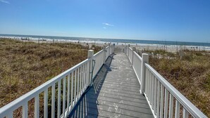 A wooden boardwalk leading to a beach with a clear sky. - 20% off weekly stays thru Sept. Sat to Sat. 4BR OF condo. Ocean Drive.  Sleeps 12. (North Myrtle Beach)