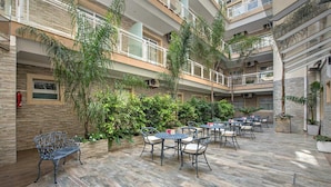 Un atrium à plusieurs niveaux doté d’un espace extérieur aménagé avec des plantes et un extincteur.