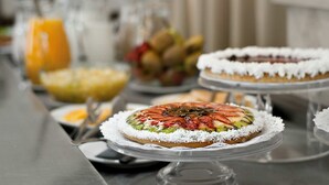 Une table de buffet proposant divers plats, notamment une tarte aux fruits et un gâteau recouvert de glaçage blanc.