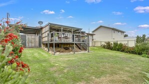 Une maison à deux étages avec un patio couvert et un garage séparé.