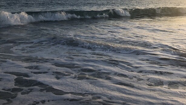 Una playa con olas y cielo despejado.