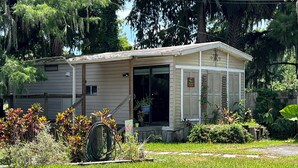 A small, single-story building with a front porch and a garage. - Waterfront Cottage on the Harris chain in Leesburg  (Leesburg)