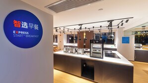 A modern breakfast area with a digital menu display, stainless steel appliances, and a clean, minimalist design. - Holiday Inn Express Shanghai Baoshan Baoyang by IHG (Shanghai)