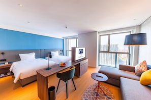 Una habitación de hotel moderna con cama, escritorio y zona de estar.