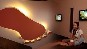 A modern interior with a large abstract wall design, a reception desk, and a television screen. - Hotel Reko Inn (Kajang)