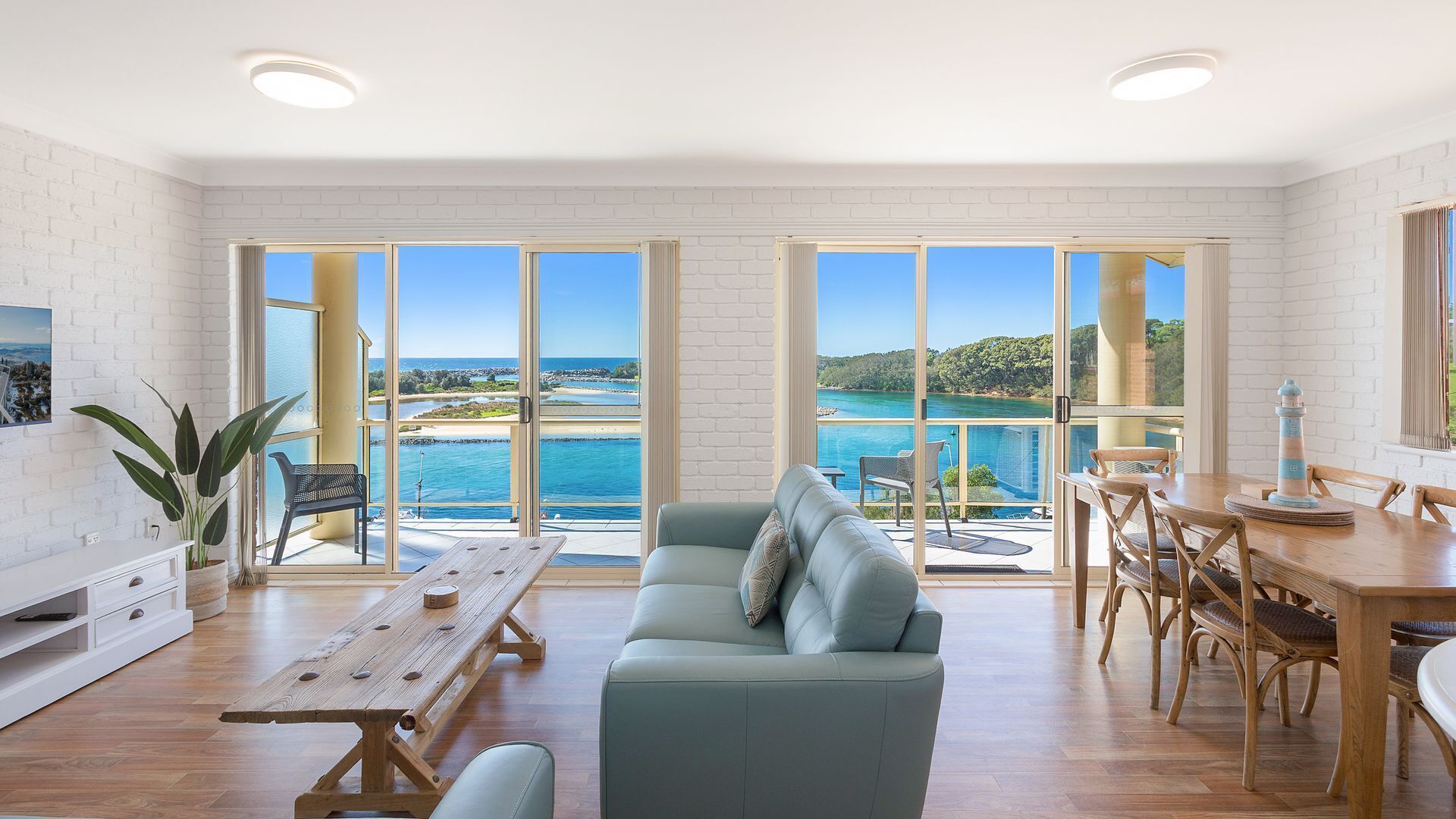 A spacious living room with a large sofa, a wooden table, and a dining area.