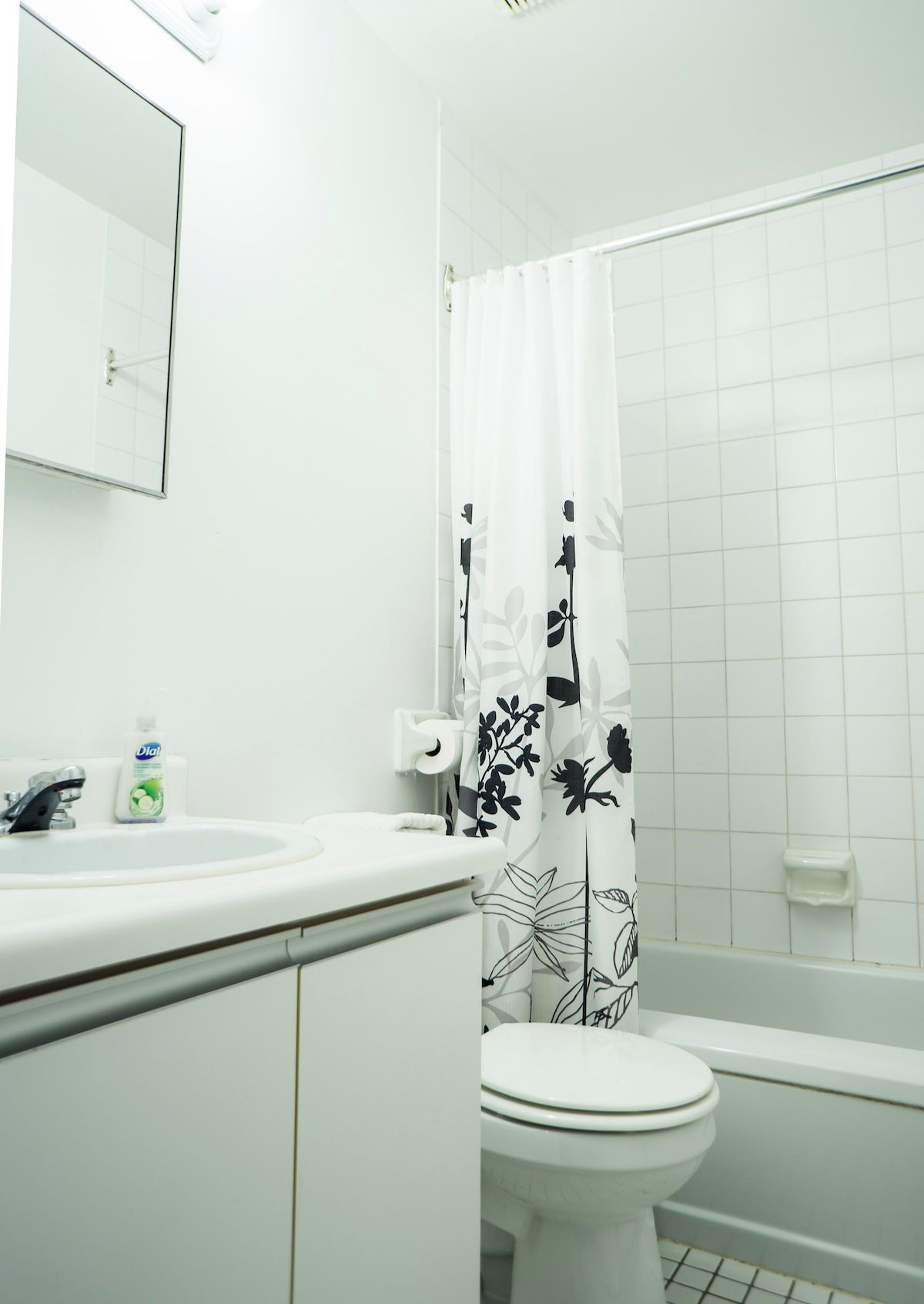 Un baño con inodoro, lavamanos y cortina de ducha.